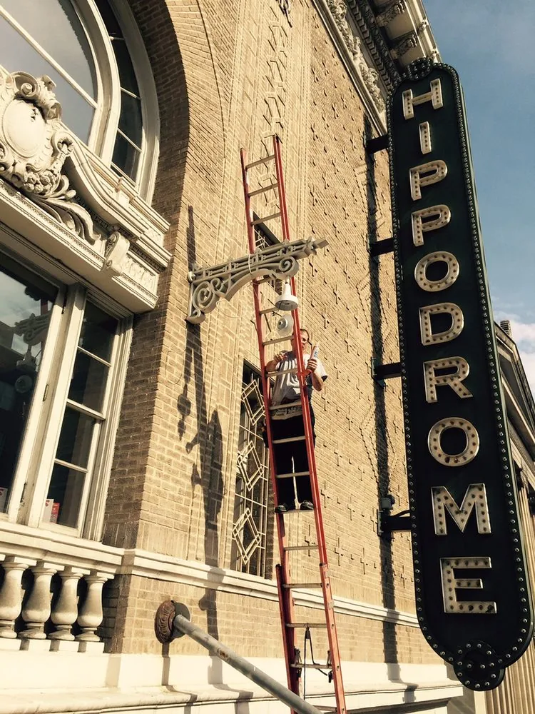A ladder against the tall vertical HIPPODROME sign on the Hippodrome Theatre in downtown Baltimore