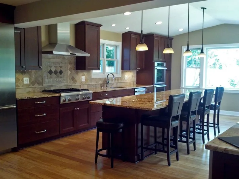 Pendant lights over a kitchen island with dark wood cabinets
