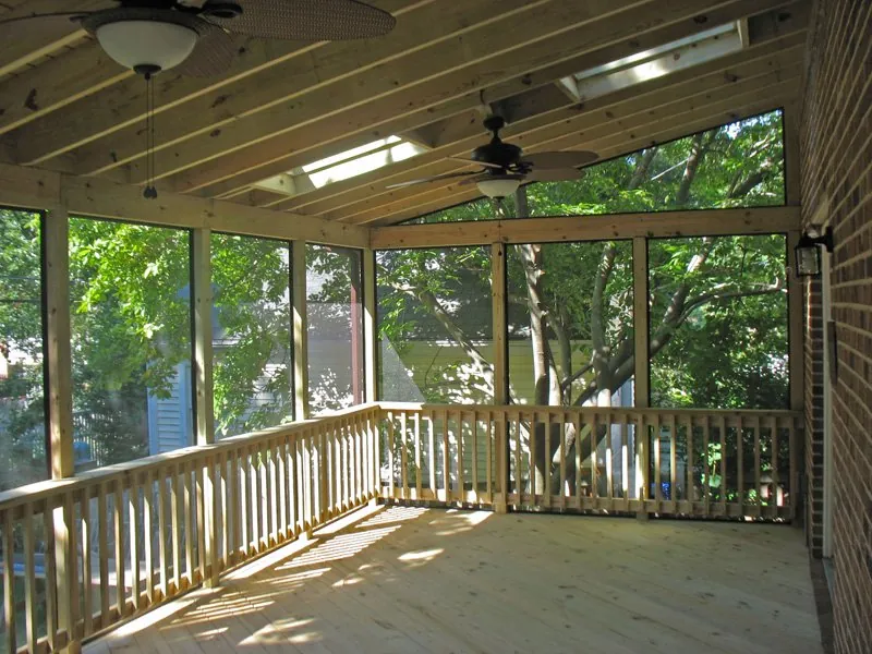 A new screened porch with exposed rafters, a ceiling fan and skylights